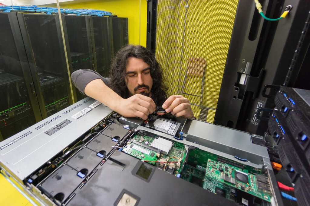 young engeneer professional technician repairing server in computer room